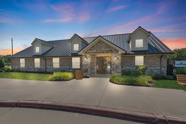 a front view of a house with a yard and potted plants
