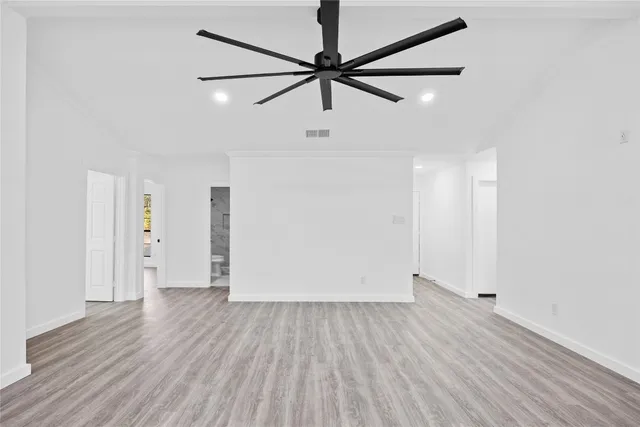 a view of a room with wooden floor and a ceiling fan