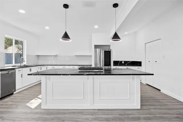 a kitchen with granite countertop a sink and cabinets