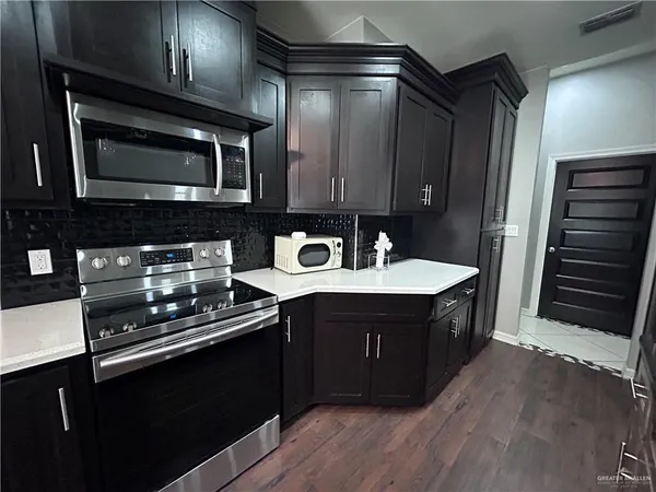 a kitchen with a sink stove and microwave
