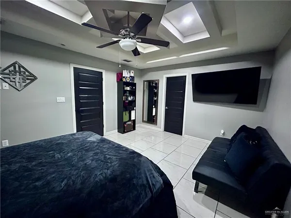 a bedroom with a bed and a flat tv screen on dresser