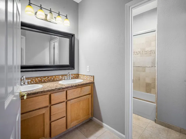 a bedroom with a bed and a dresser with mirror