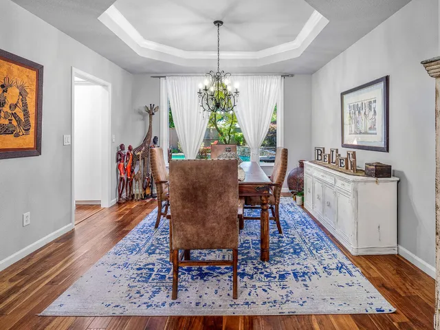 a kitchen with a sink a counter top space dining table and a flat screen tv