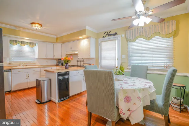 a kitchen with stainless steel appliances granite countertop a sink a stove and white cabinets
