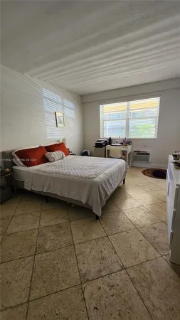 a bedroom with a bed and large windows