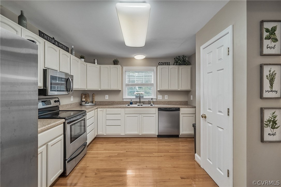 2617 Lampworth Road Henrico, VA 23231 - Photo 6 of 45 a kitchen with a sink white cabinets and stainless steel appliances
