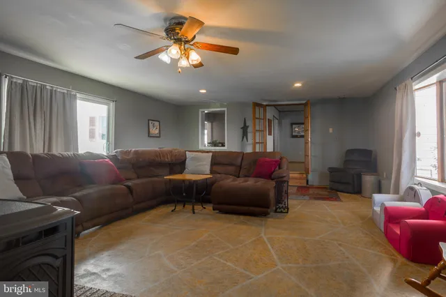 a living room with furniture a flat screen tv and a large window