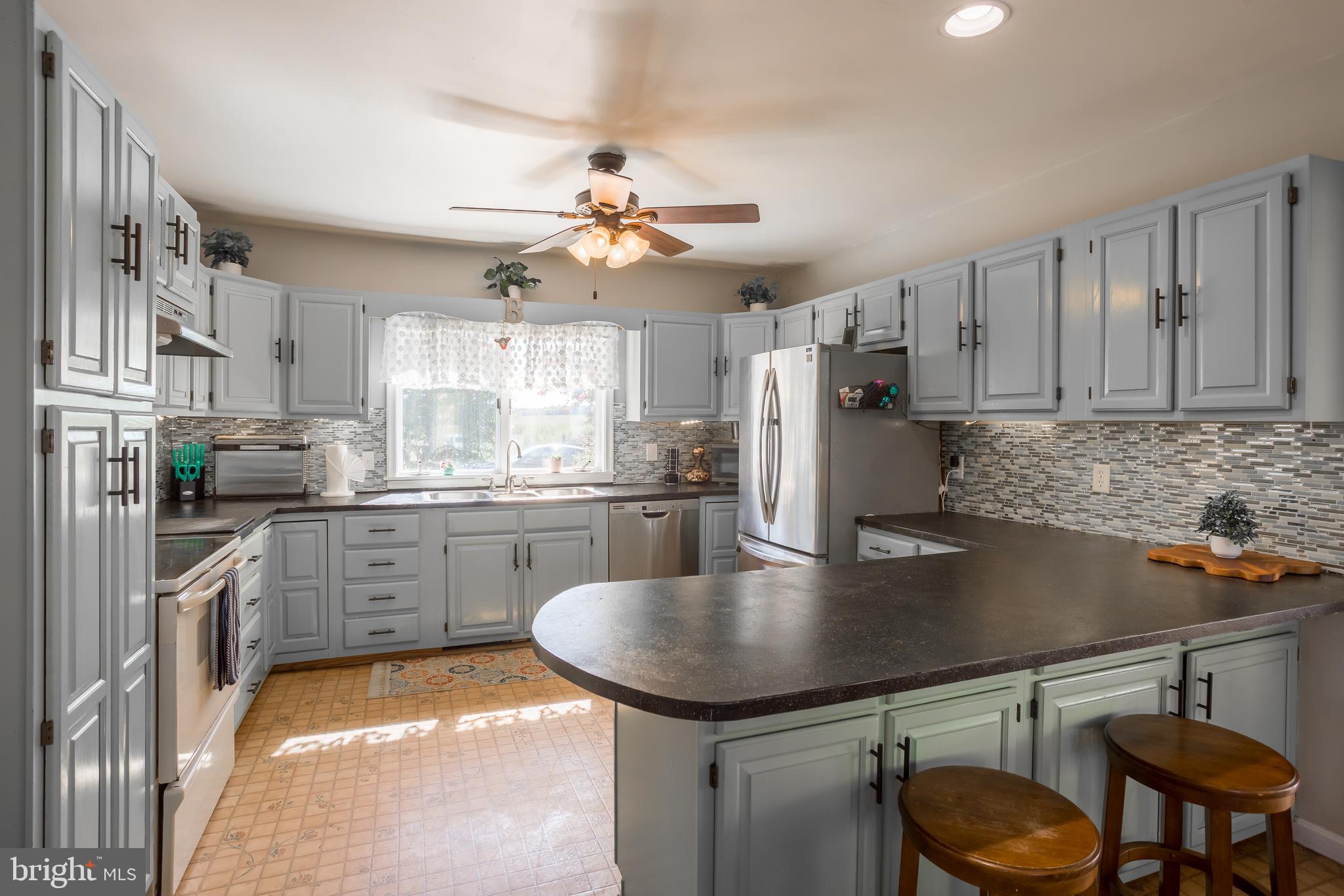 10380 Chapel Road Easton, MD 21601 - Photo 26 of 95 a kitchen with stainless steel appliances granite countertop a sink a stove a refrigerator cabinets and chairs