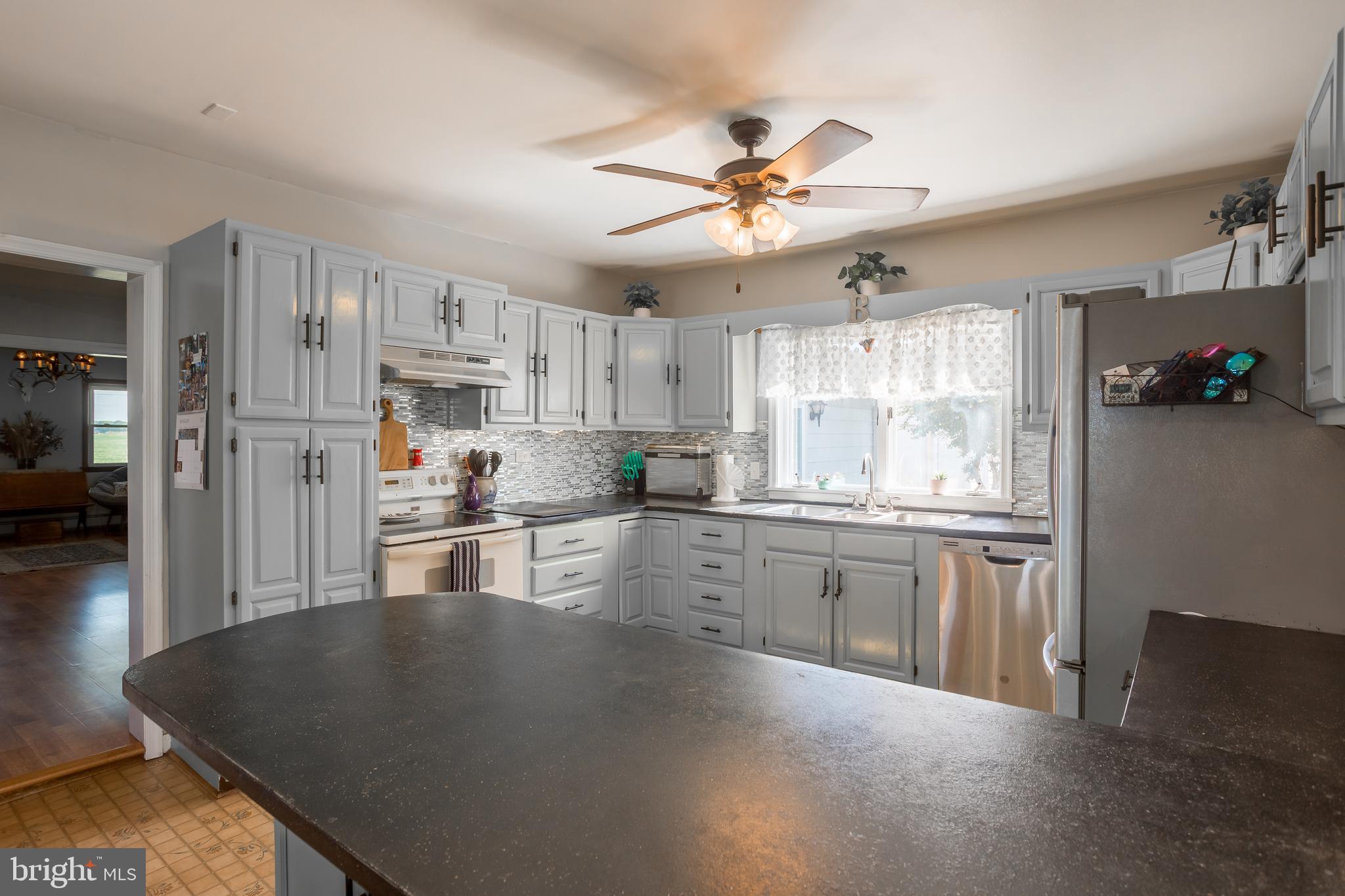 10380 Chapel Road Easton, MD 21601 - Photo 27 of 95 a kitchen with stainless steel appliances granite countertop a sink refrigerator stove and white cabinets