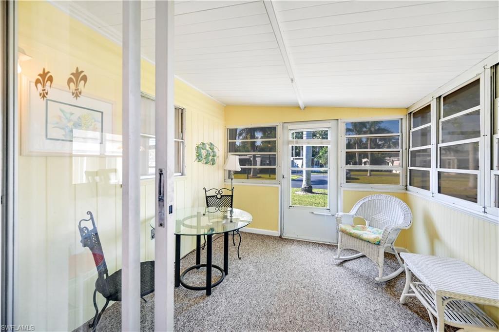11 Moonstone Circle Naples, FL 34112 - Photo 11 of 20 a living room filled with furniture and a floor to ceiling window