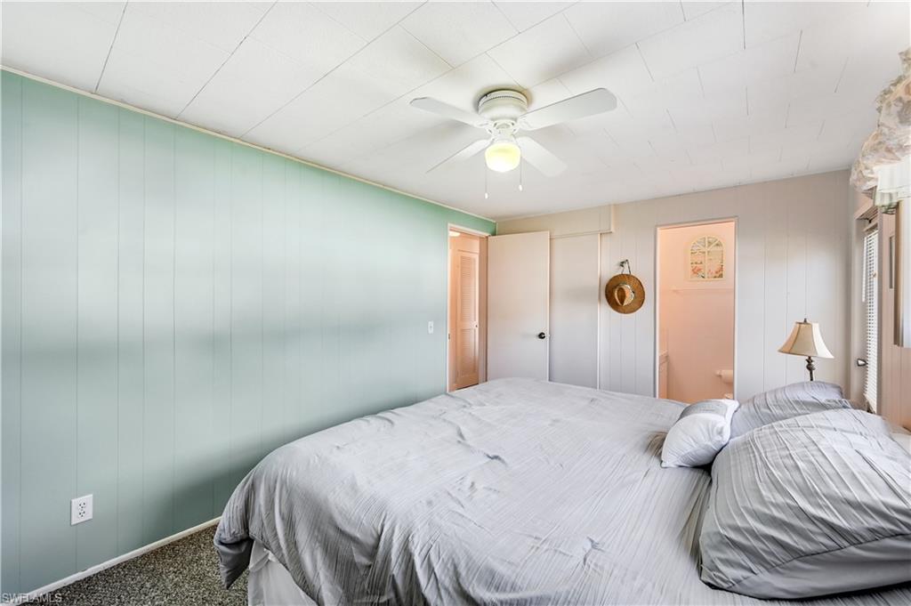 11 Moonstone Circle Naples, FL 34112 - Photo 14 of 20 a bedroom with a bed and a chandelier