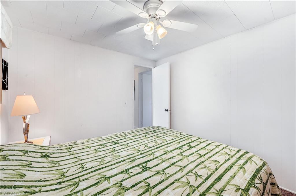 11 Moonstone Circle Naples, FL 34112 - Photo 17 of 20 a bedroom with a bed and a chandelier