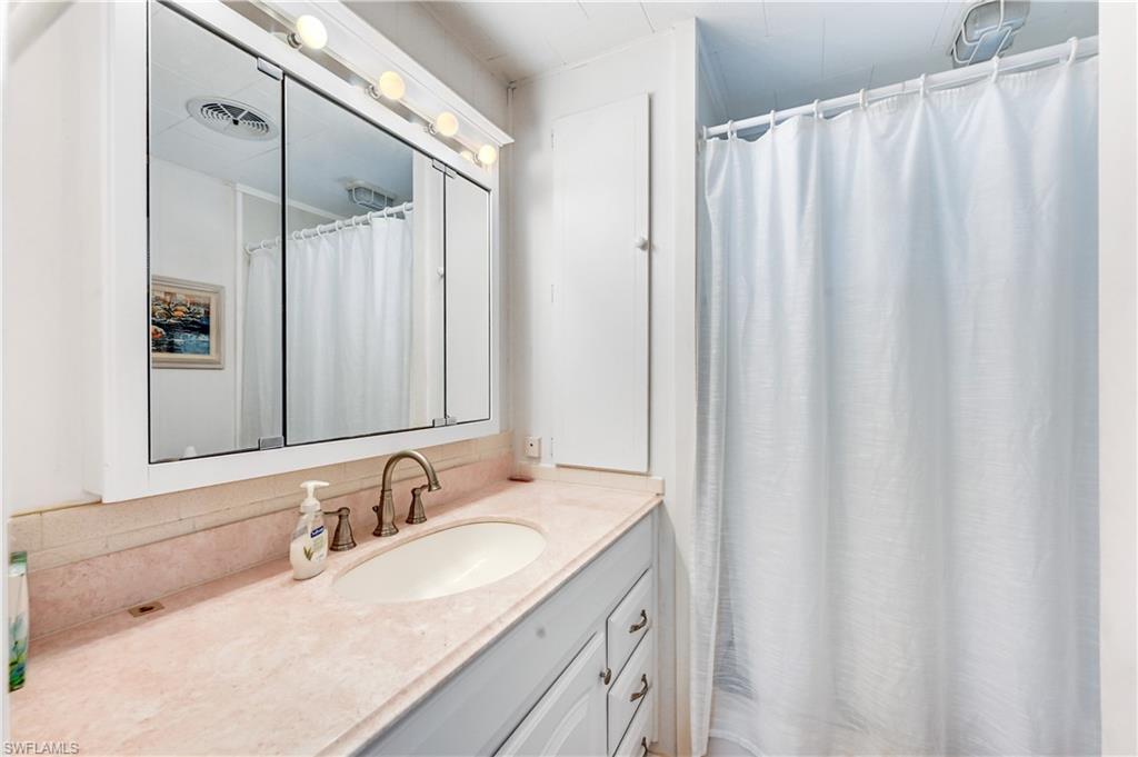11 Moonstone Circle Naples, FL 34112 - Photo 18 of 20 a bathroom with a granite countertop sink and a mirror