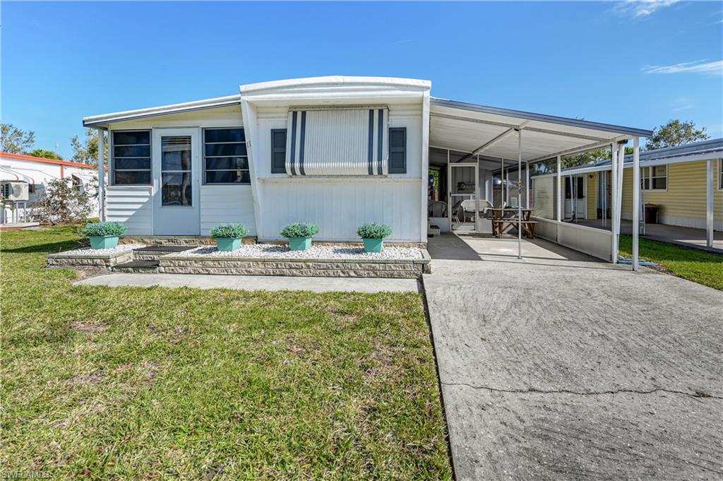 11 Moonstone Circle Naples, FL 34112 - Photo 2 of 20 a front view of house with yard outdoor seating and barbeque oven