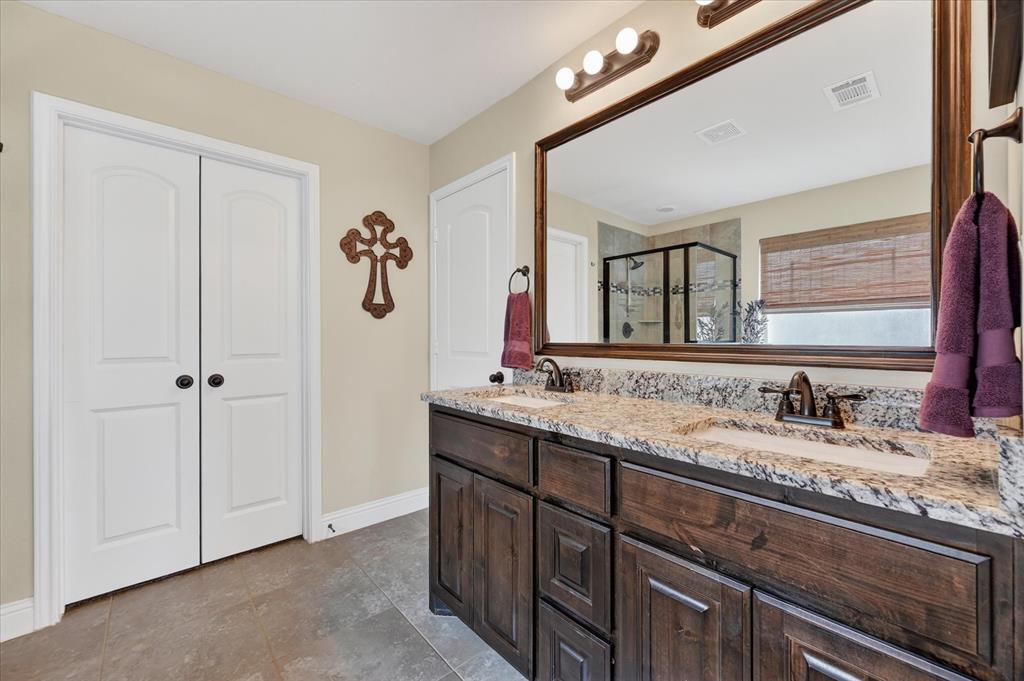 106 Zion Lane Forney, TX 75126 - Photo 17 of 37 a bathroom with a granite countertop sink a mirror and shower