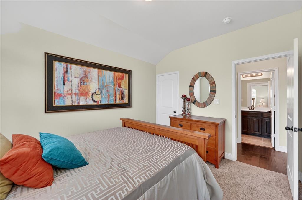 106 Zion Lane Forney, TX 75126 - Photo 21 of 37 a bedroom with a bed mirror on wall and a large window