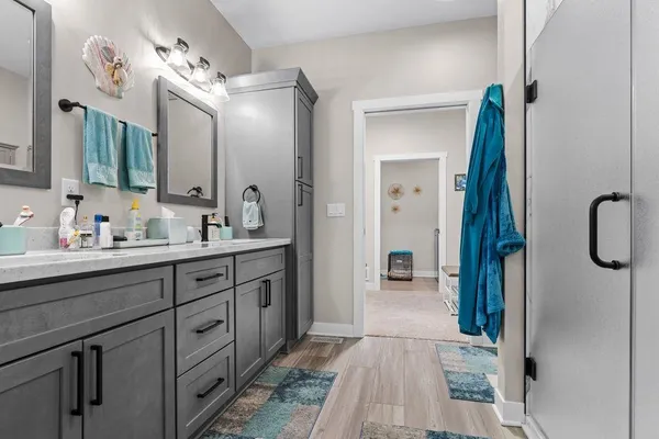 a spacious bathroom with a double vanity sink a mirror and shower