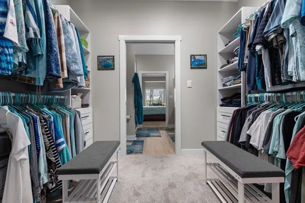 a view of walk in closet with clothes and shoes