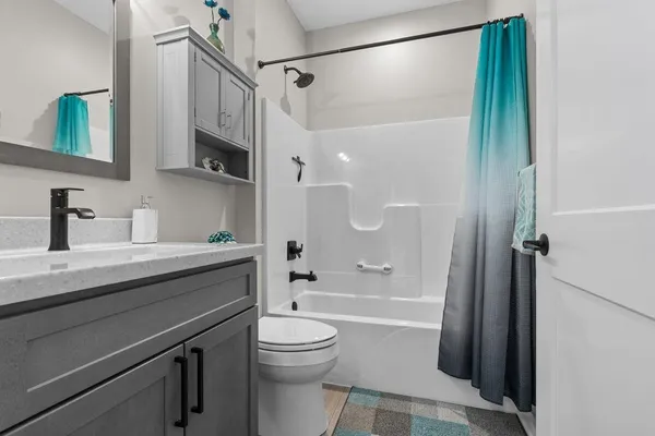 a bathroom with a sink a toilet a mirror and shower