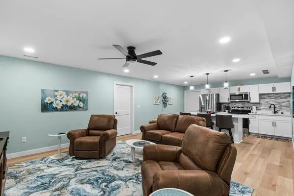 a living room with furniture kitchen view and a window