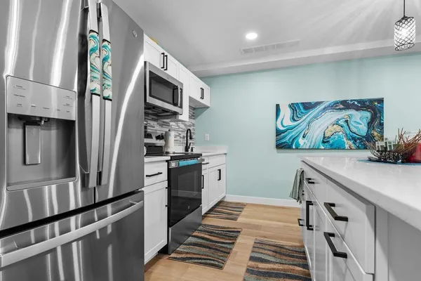 a kitchen with stainless steel appliances a refrigerator and a stove top oven