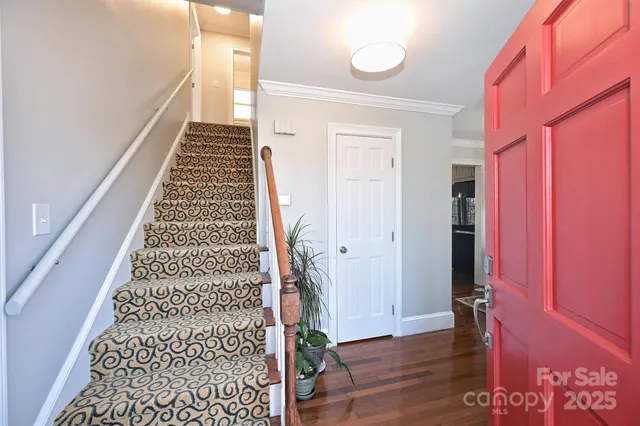 a view of a hallway with wooden floor and a potted plant