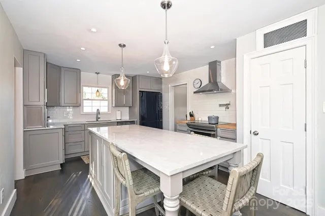 a kitchen with a table chairs sink and cabinets