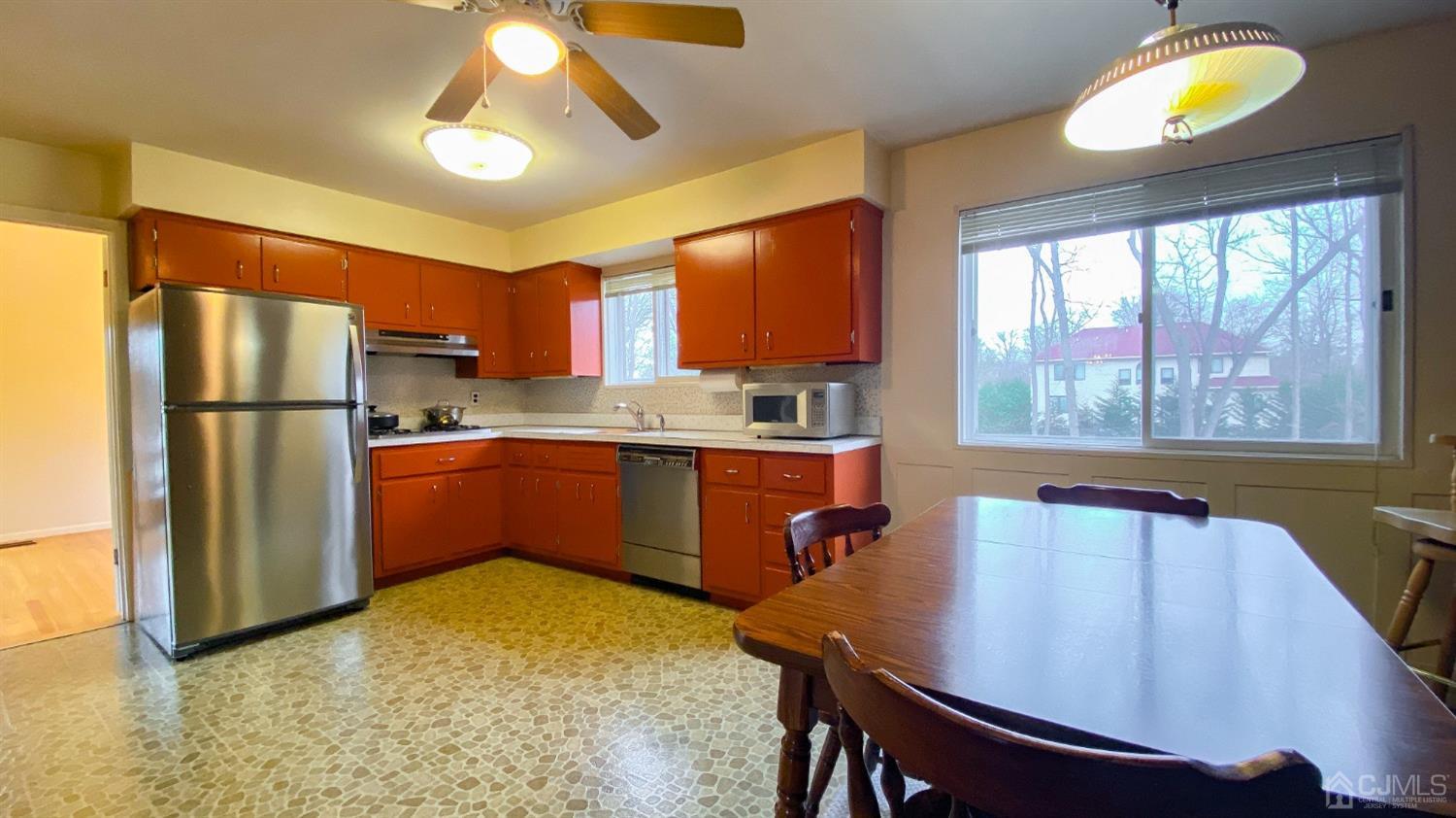 61 Stephenville Parkway Edison, NJ 08820 - Photo 8 of 32 a kitchen with a refrigerator a stove a sink and a dining table with chairs