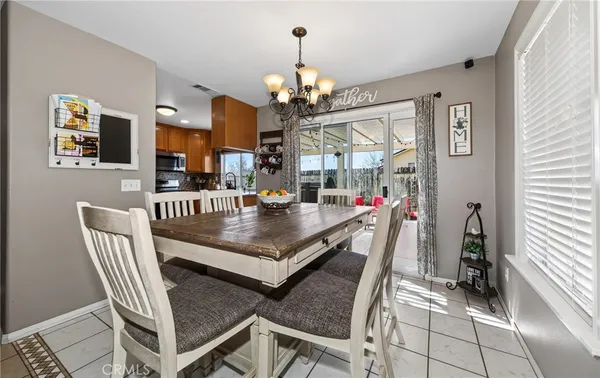 a dining room with furniture a chandelier and window