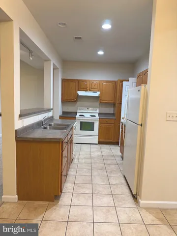 a kitchen with granite countertop a refrigerator and a sink