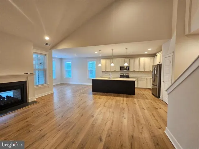 a view of a livingroom with wooden floor and a fireplace