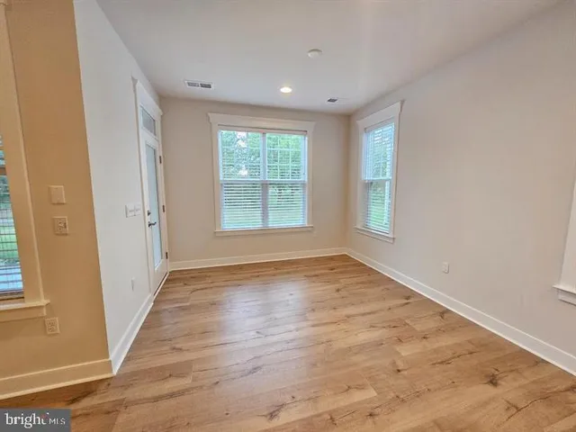 a view of a kitchen with kitchen island a sink wooden floor and a living room