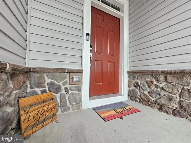 a backyard of a house with wooden fence and a red door
