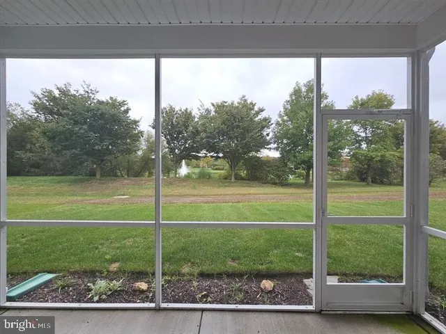 a view of a yard in front of a house with a large tree