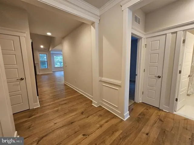 a view of a hallway with wooden floor and staircase