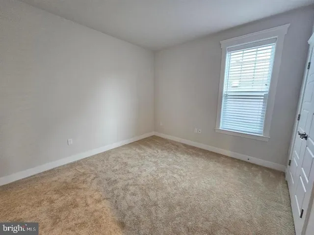 a large white kitchen with a fireplace and wooden floor