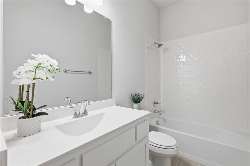 4017 Alpine Street Midlothian, TX 76065 - Photo 29 of 37 Bathroom featuring a white vanity with integrated sink, chrome faucet, and a large wall-mounted mirror