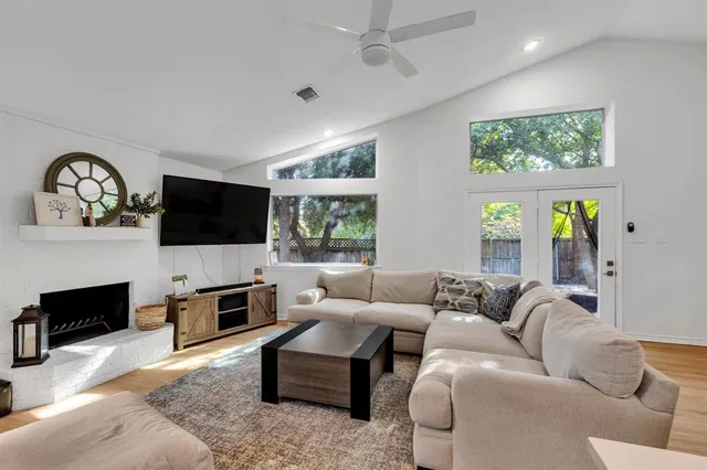 a dining room with wooden floor a chandelier a wooden table and chairs