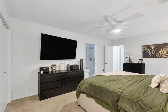 a bedroom with a bed and a flat tv screen on the dresser