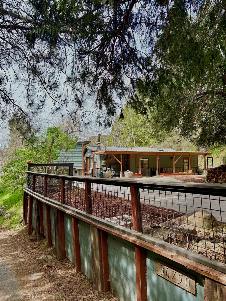 36750 Hilltop Road Yucaipa, CA 92399 - Photo 1 of 27 a view of a balcony with wooden floor and fence
