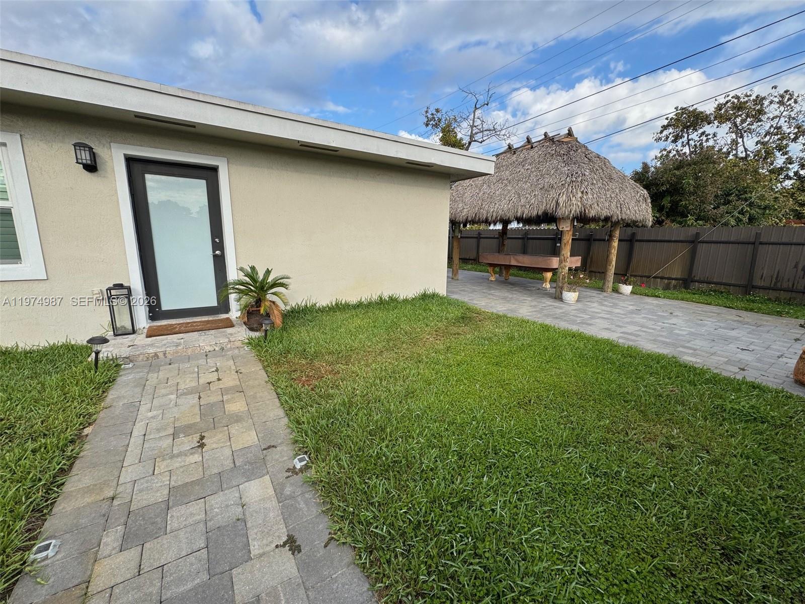 211 West 33rd Street, Unit 2 Hialeah, FL 33012 - Photo 2 of 9 a backyard of a house with table and chairs