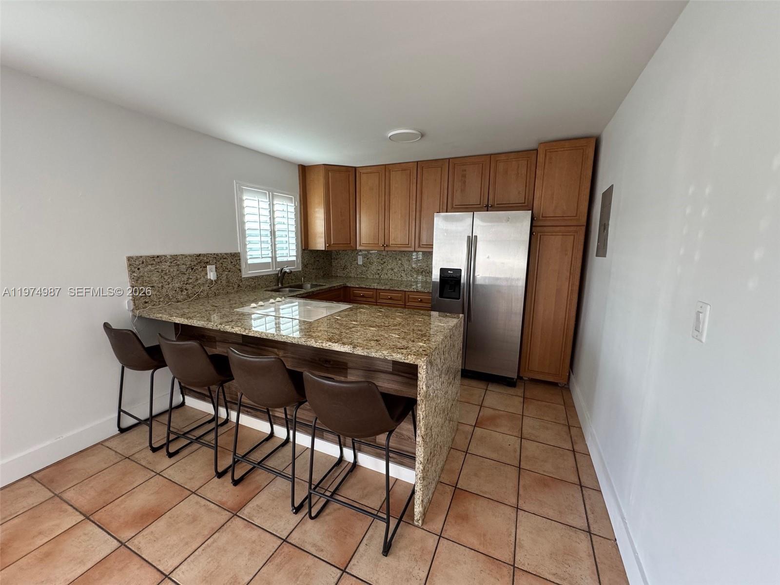 211 West 33rd Street, Unit 2 Hialeah, FL 33012 - Photo 4 of 9 a kitchen with stainless steel appliances granite countertop a sink and a refrigerator