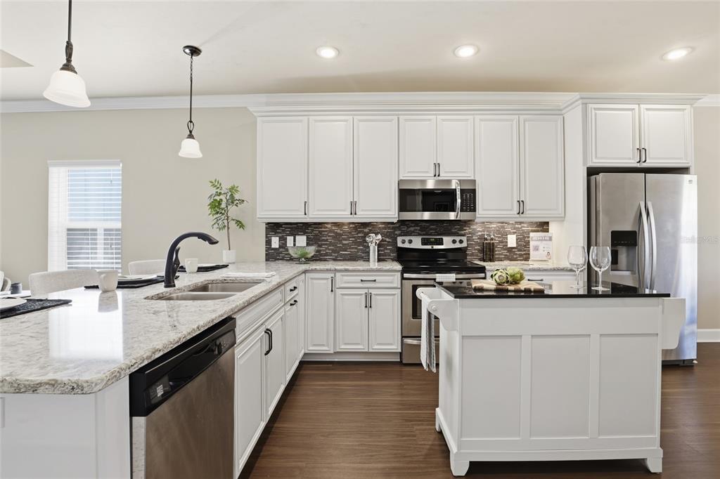 7894 Southwest 80th Drive Gainesville, FL 32608 - Photo 11 of 31 a kitchen with stainless steel appliances granite countertop a sink a stove top oven a refrigerator and dishwasher