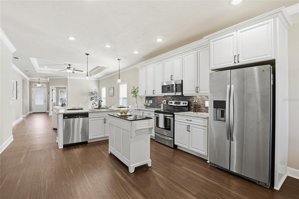 7894 Southwest 80th Drive Gainesville, FL 32608 - Photo 12 of 31 a kitchen with white cabinets and stainless steel appliances