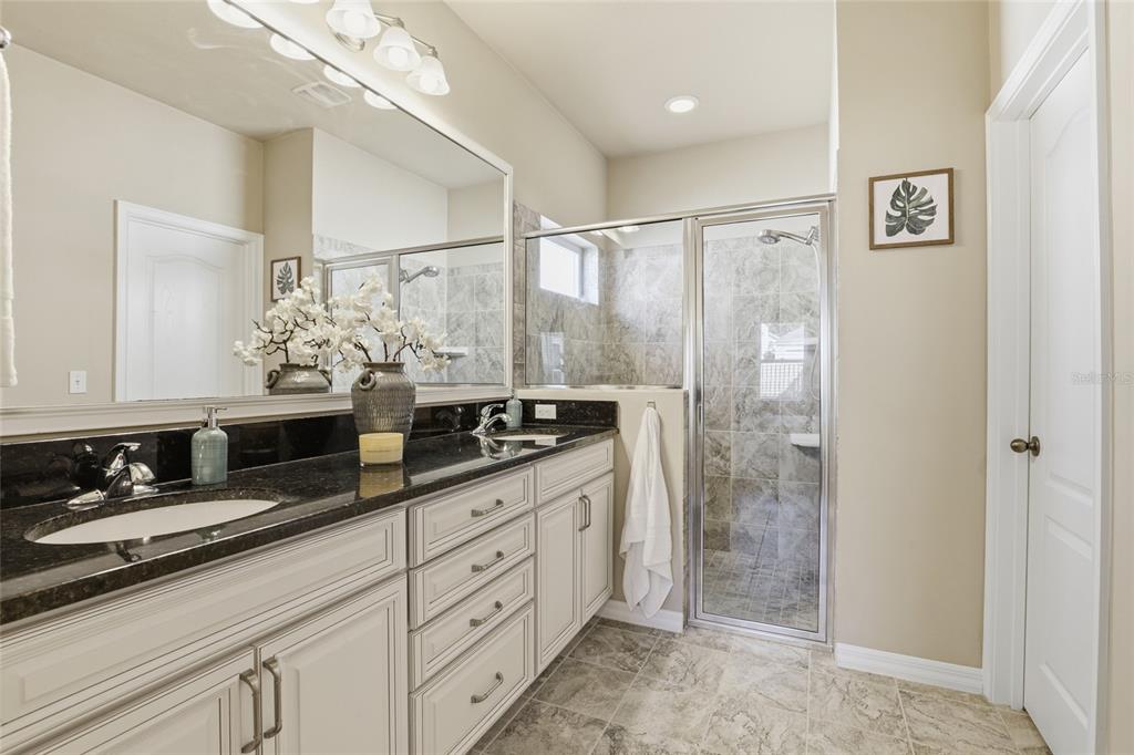 7894 Southwest 80th Drive Gainesville, FL 32608 - Photo 20 of 31 a bathroom with a double vanity sink mirror and shower