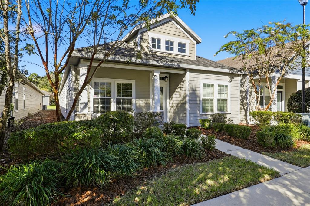 7894 Southwest 80th Drive Gainesville, FL 32608 - Photo 29 of 31 a view of a white house with large windows and a small yard