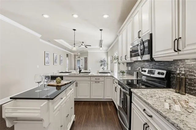 a kitchen with stainless steel appliances granite countertop a sink a stove and a refrigerator