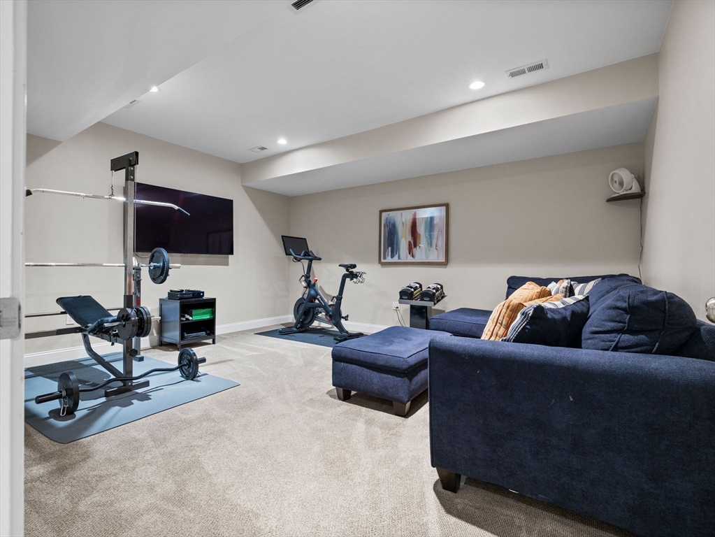 24 Jackson Road Wellesley, MA 02481 - Photo 29 of 36 a living room with furniture gym equipment and a flat screen tv