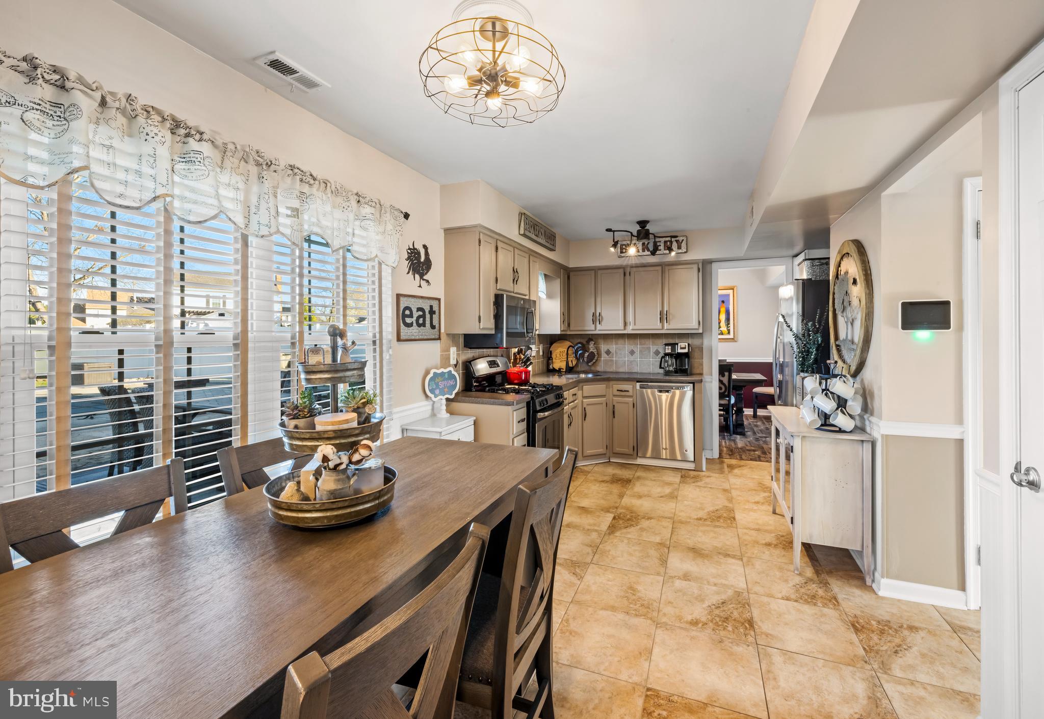 34 Borrelly Boulevard Sewell, NJ 08080 - Photo 7 of 23 a kitchen with stainless steel appliances a table chairs and a refrigerator
