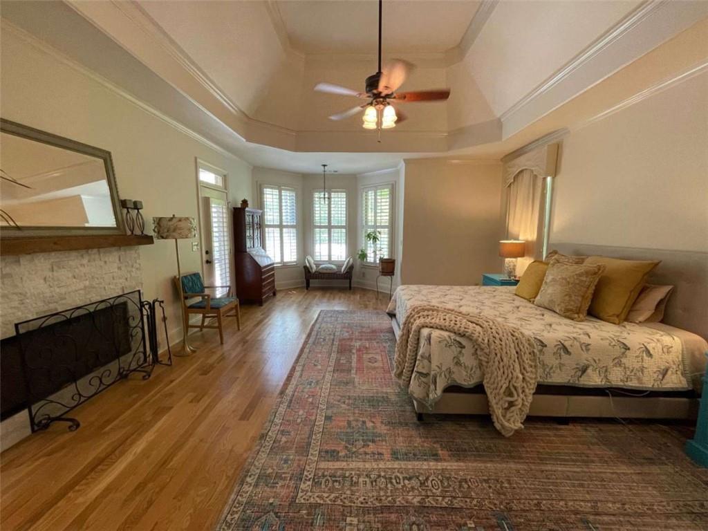 1531 Overlook Pass Road Monroe, GA 30655 - Photo 26 of 78 a spacious bedroom with a bed a fireplace and a chandelier